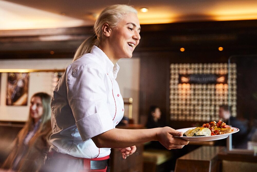 Hamburg Jungfernstieg Kellnerin serviert Essen in einem BLOCK HOUSE Restaurant