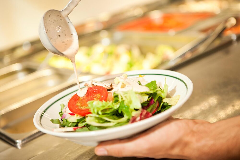 Hamburg Winterhude BLOCK HOUSE American Dressing wird auf einen Salat gegossen